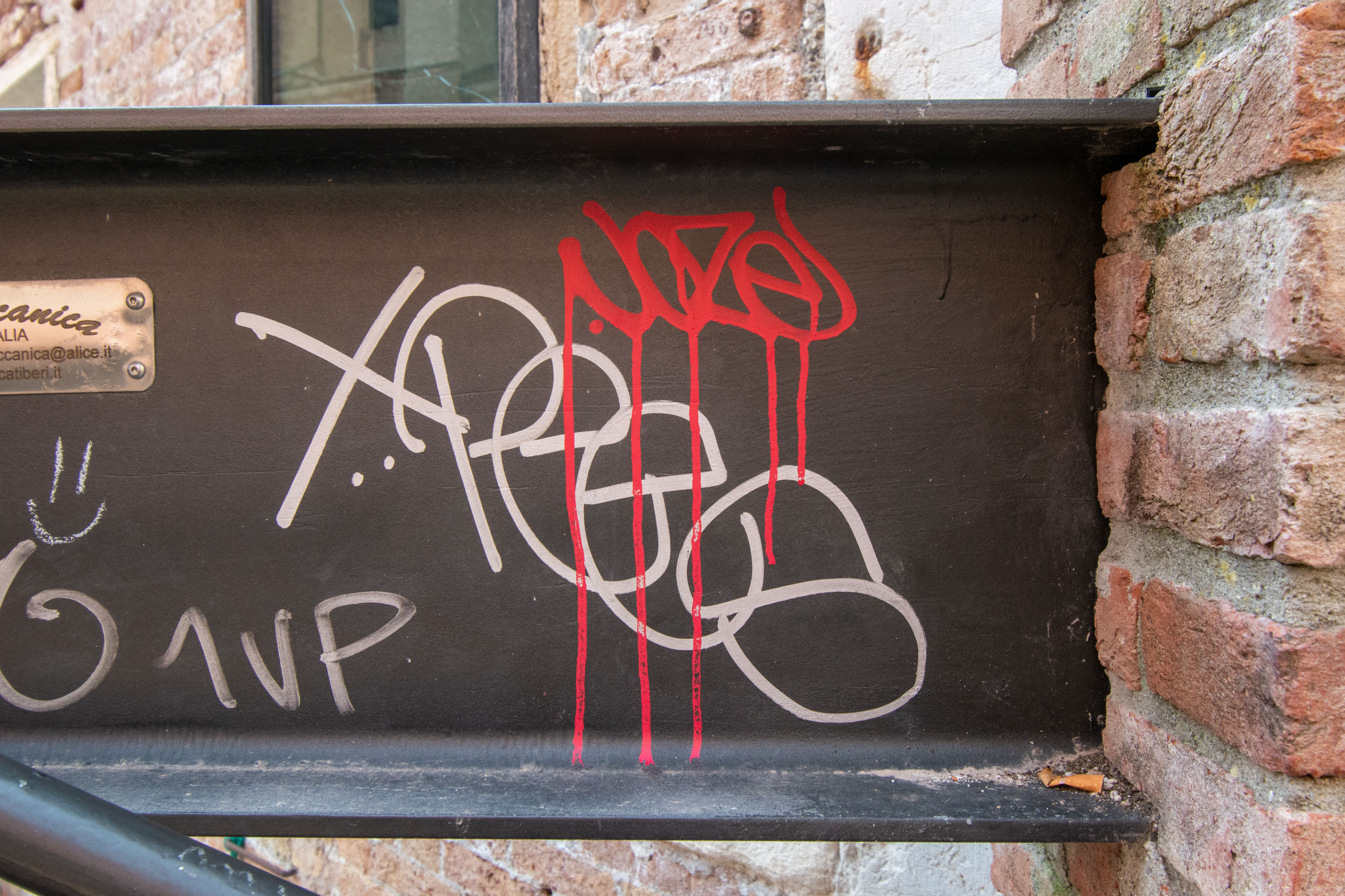 Urban Photographers - Graffiti Background - Close-up photo of hand-scrawled, painted graffiti on a steel beam in Venice, Italy.