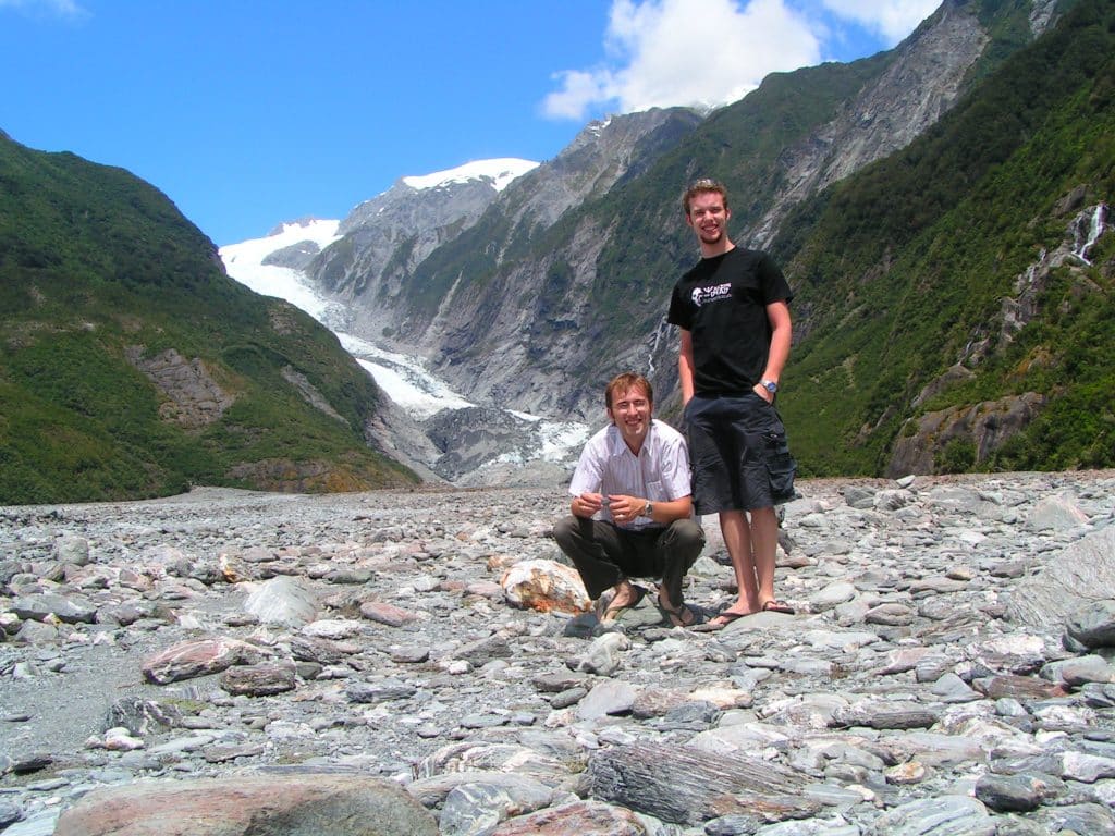 Two brothers stand in the creekbed below Franz Josef Glacier on New Zealand's West Coast. The Glacier forms part of Westland Tai Poutini National Park, and is receding rapidly due to climate change and global warming.