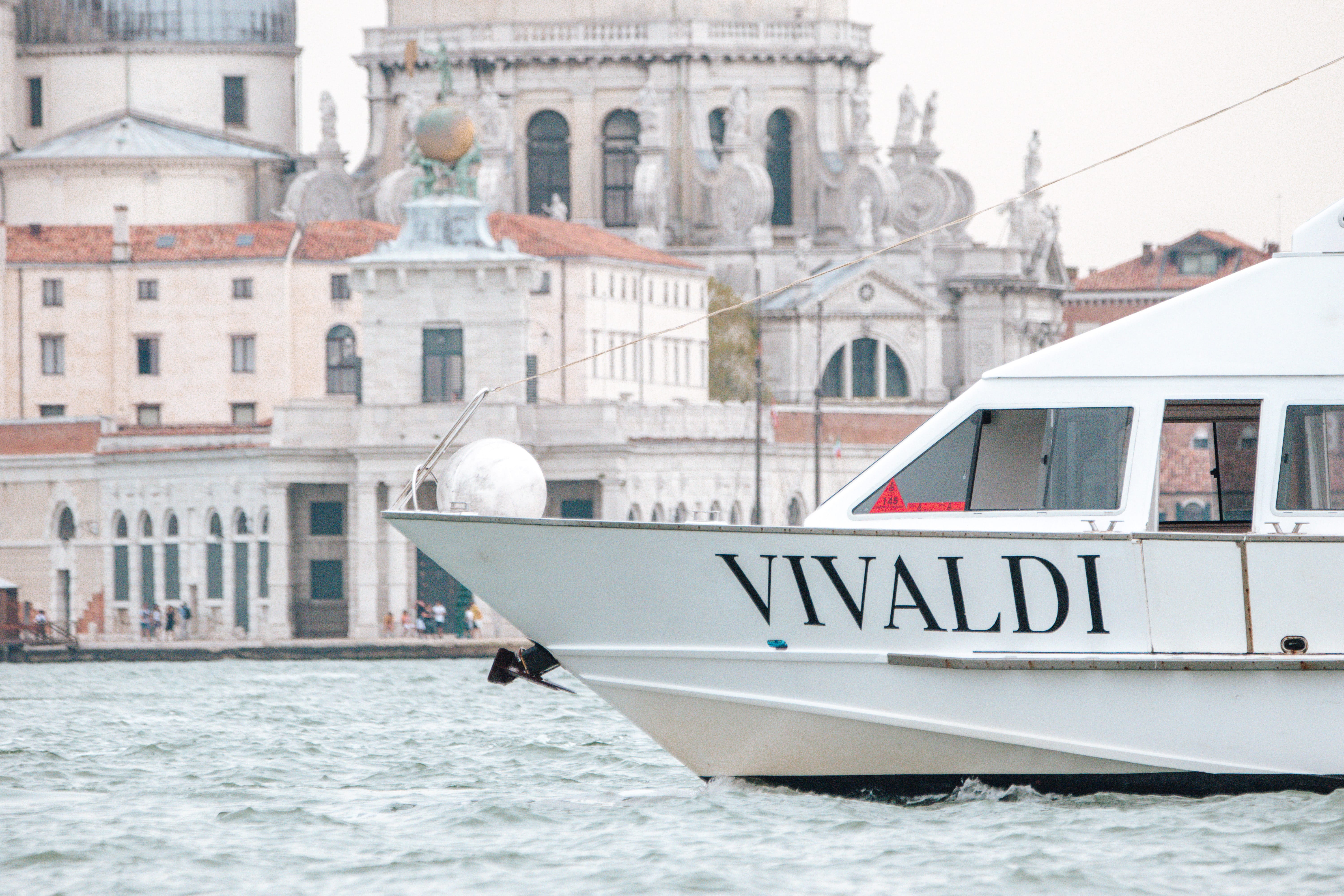 Venice Airport Transfer - Airport Water Taxi - A private water taxi approaches in the water near Venice, Italy. Wooden boats serve as private transportation throughout Venice, but are much more expensive than public transportation options