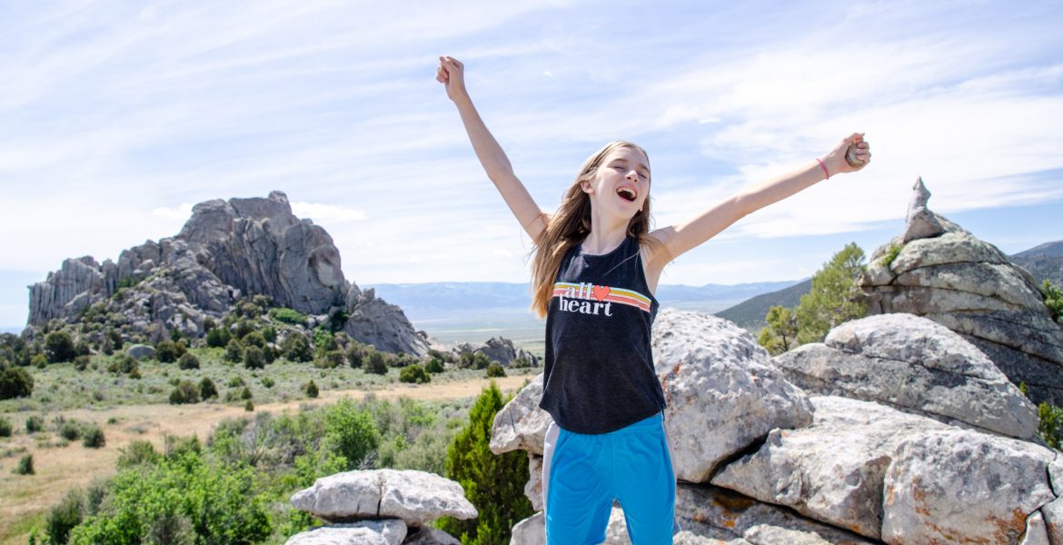 Explore the Best Hiking in Castle Rocks State Park Idaho. A young girl stands atop massive boulders inside the Castle Rocks State Park Idaho complex.