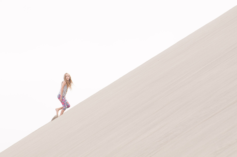 A young girl hikes up a 45-degree sand dune at Bruneau Sand Dunes in Southwestern Idaho. Bruneau Sand Dunes is the tallest free-standing dune in North America.