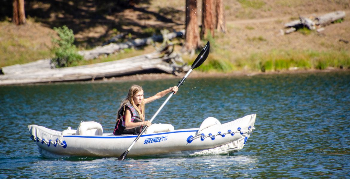 Best Place to Kayak - Magone Lake in Oregon. Several kayaks sit along the shore of Magone Lake, a natural lake created by a landslide in the early 1800s.